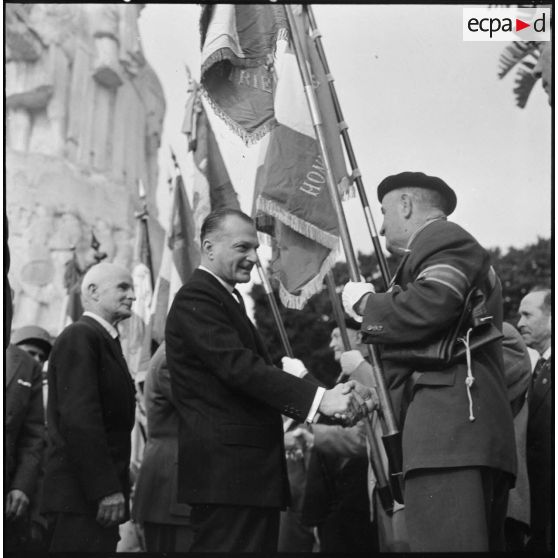 Alger. Cérémonies du 11 Novembre. Paul Delouvrier salue les anciens combattants porte-drapeaux.