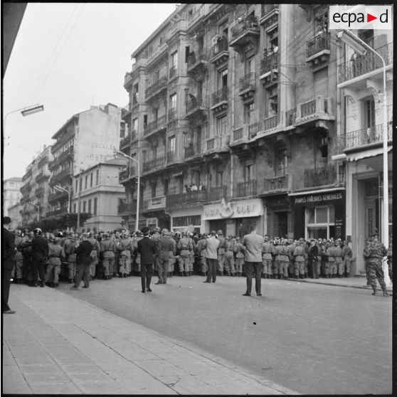 Alger. Cérémonies du 11 Novembre. La foule est maintenue par un fort cordon de la compagnie républicaine de sécurité (CRS) et de gendarmes.