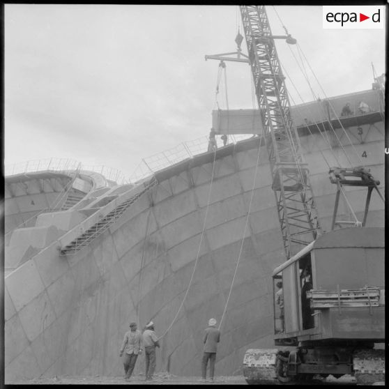 Construction du barrage du Mefrouch. Guidage au sol d'un élément de voute.