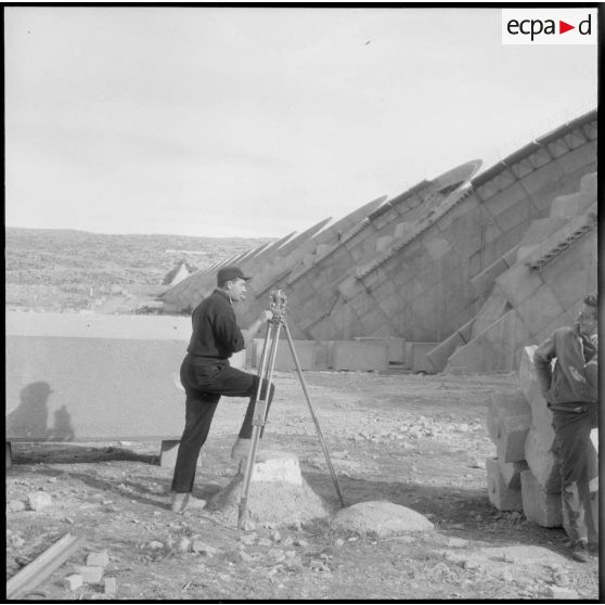 Construction du barrage du Mefrouch. Technicien faisant un relevé.