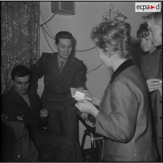 Alger. Infirmerie de garnison. Réveillon de noël 1960. Pendant le tirage de la loterie, madame la colonel Sobra remet un lot à un jeune militaire.
