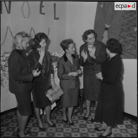 Alger. Infirmerie de garnison. Réveillon de noël 1960. Madame la colonel Santini et madame la colonel Sobra, assistées par deux jeunes filles, devant la table aux cadeaux.