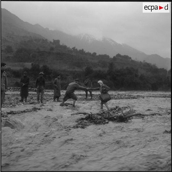 Gorges de Kerrata. Harka 318. Les harkis aident un civil à passer l'oued en crue.