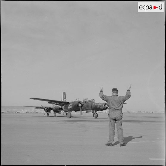 Le groupe Guyenne. Un mécanicien donne les instructions par geste au pilote pour le parcage du Douglas B 26 Invader.