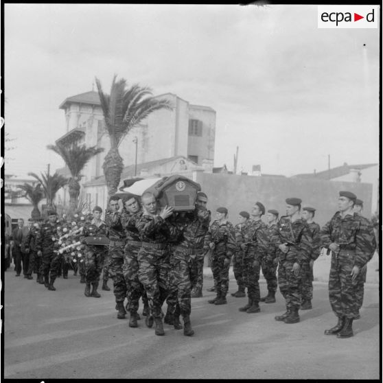 Guyotville. La dépouille mortelle du lieutenant Calmon portée par six parachutistes passe devant une section au "présentez-arme".