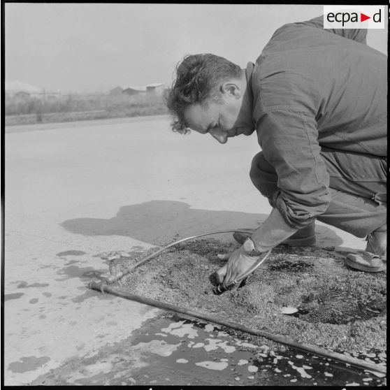 Aérodrome de Maison Blanche. Chantier de la nouvelle piste Est-Ouest en béton précontraint. Gonflage des vérins (60 kg par cm²).