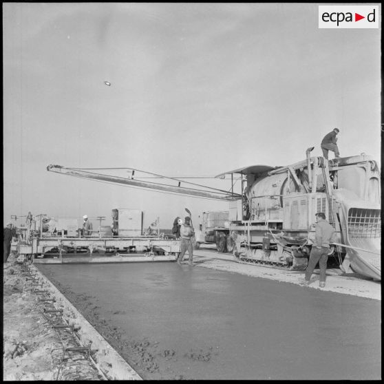 Aérodrome de Maison Blanche. Chantier de la nouvelle piste Est-Ouest en béton précontraint. Un paveur.