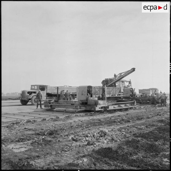 Aérodrome de Maison Blanche. Chantier de la nouvelle piste Est-Ouest en béton précontraint. Ensemble du paveur et de la repoudreuse automatique.