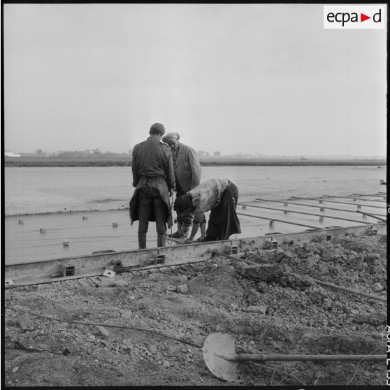 Aérodrome de Maison Blanche. Chantier de la nouvelle piste Est-Ouest en béton précontraint. Des barres de fer sont placées avant le coulage du béton pour permettre le logement des câbles.
