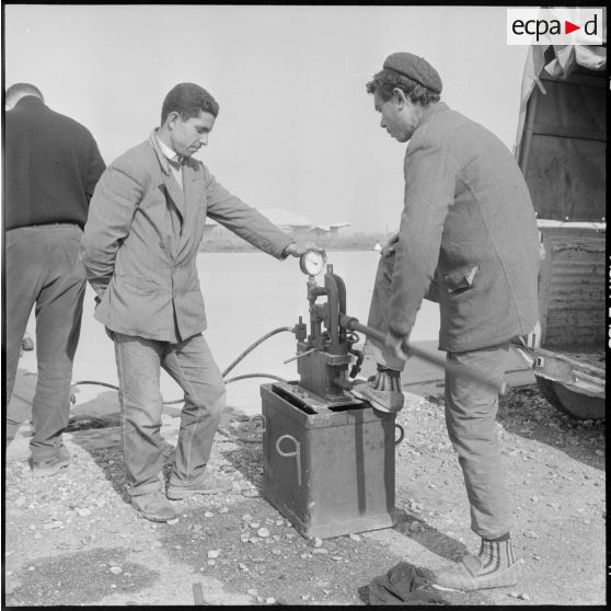 Aérodrome de Maison Blanche. Chantier de la nouvelle piste Est-Ouest en béton précontraint. Gonflage des vérins (60 kg par cm²).