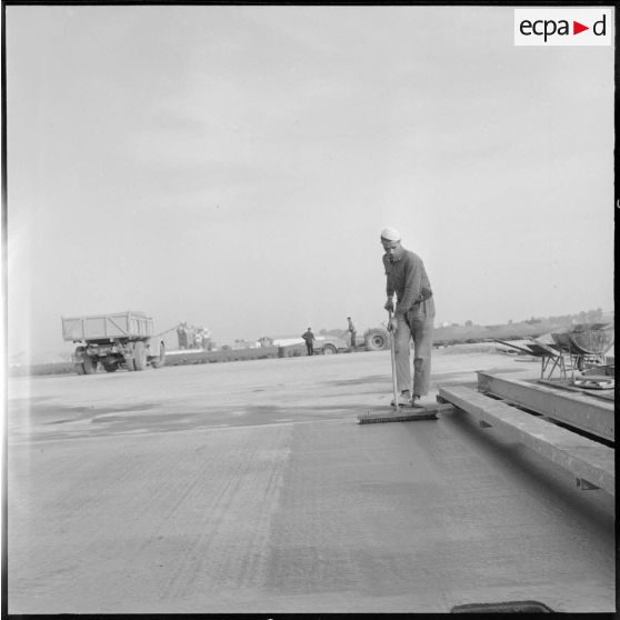 Aérodrome de Maison Blanche. Chantier de la nouvelle piste Est-Ouest en béton précontraint. Passage du balai en nylon.
