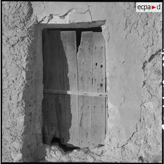 Ouled Sayah. Une planche de bois sur une façade.