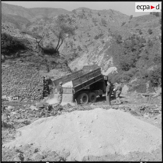 Chaîne des Babors. 69e bataillon du génie (BG). Les matériaux pour la construction du pont arrivent. Déchargement de gravier.