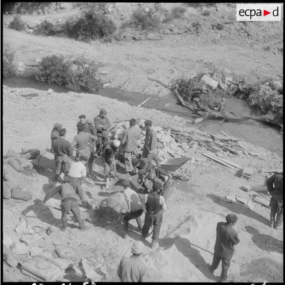 Chaîne des Babors. 69e bataillon du génie (BG). Civils mélangeant le mortier pour la construction du pont.
