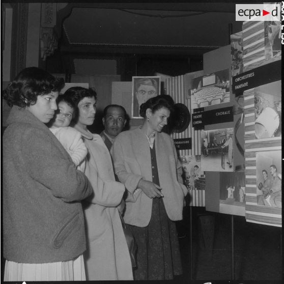 Alger. Hall du journal Le Bled. Exposition "Activités et loisirs". Des femmes regardent les panneaux concernant la chorale, les orchestres et la fanfare.