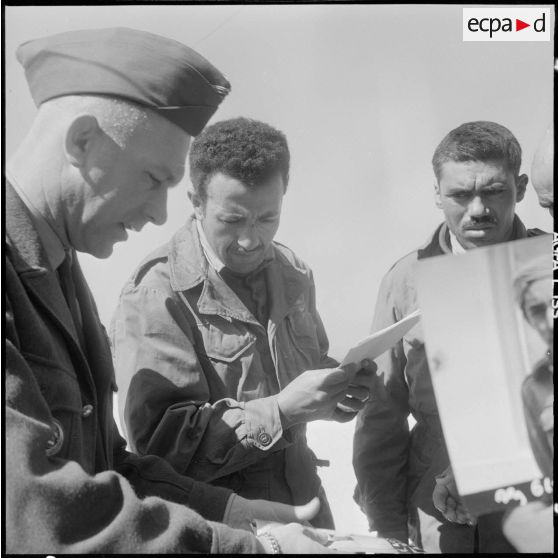Prisonniers rebelles regardant les photos des prisonniers précédents.