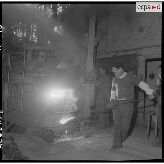 Oran. Ateliers et fonderies Célestin Ducros (AFCD). Maître de four faisant un pélèvement de métal en fusion en vue d'analyses.