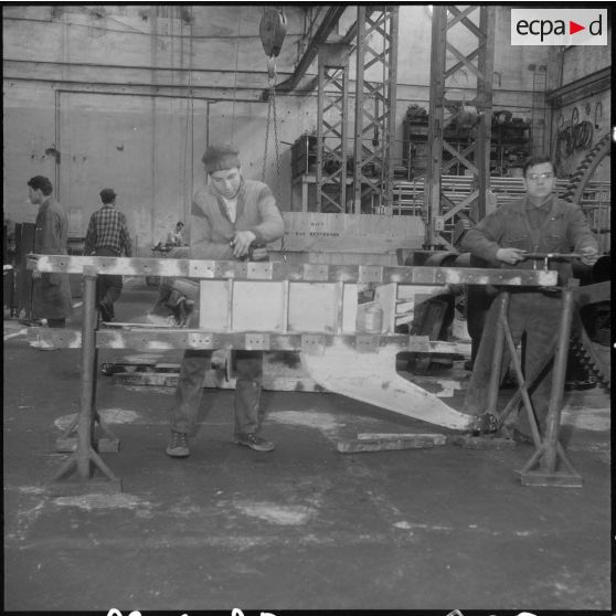Oran. Ateliers et fonderies Célestin Ducros (AFCD). Ouvriers au travail sur un bâti support de chenilles.