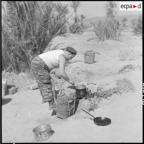 Algérie. 4e compagnie saharienne portée de légion (CSPL). Un soldat cuisine.