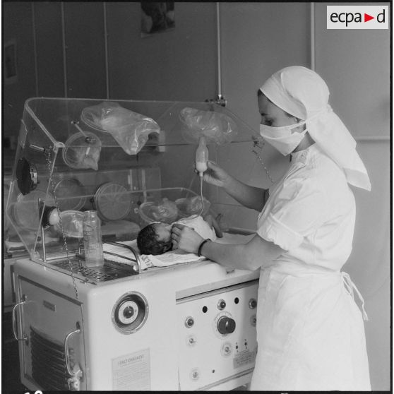 Tlemcen. Hôpital civil. Un infirmière s'occupe d'un bébé.