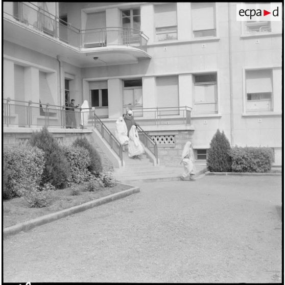 Tlemcen. Hôpital civil. Des femmes et des hommes sortent d'un bâtiment.