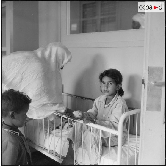 Tlemcen. Hôpital civil. Une enfant dans son lit.
