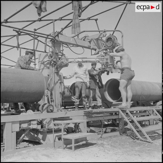 Sahara. Diverses opérations du conjointement des tubes de pipe-line et par la suite soudage.