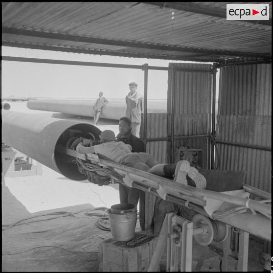 Sahara. Le soudeur sur un chariot s'apprête à entrer dans le pipe-line pour y faire sa soudure.
