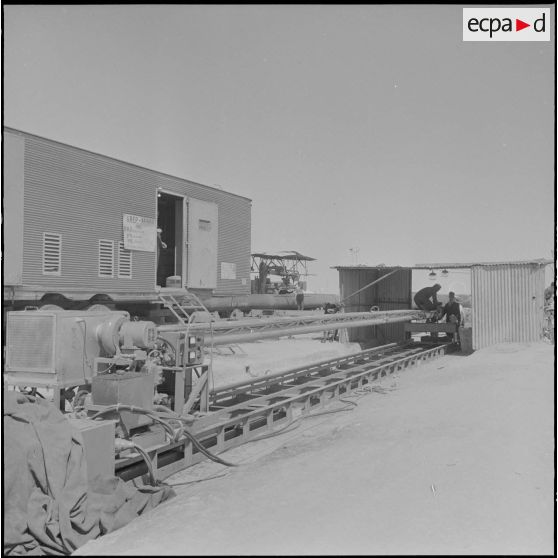 Sahara. Le soudeur allongé sur le chariot prêt à entrer à l'intérieur du tube du pipe-line.