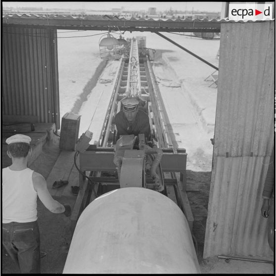 Sahara. Le soudeur allongé sur le chariot prêt à entrer à l'intérieur du tube du pipe-line.