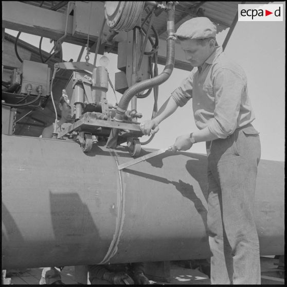 Sahara. Après la soudure sur la face externe du pipe-line on supprime les bavures.