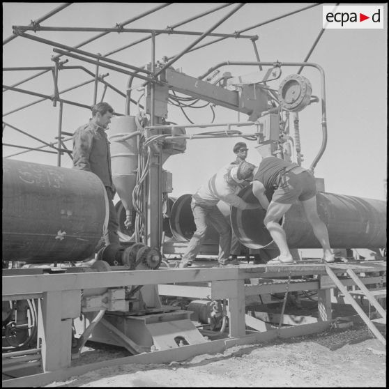 Sahara. Diverses opérations du conjointement des tubes de pipe-line et par la suite soudage.