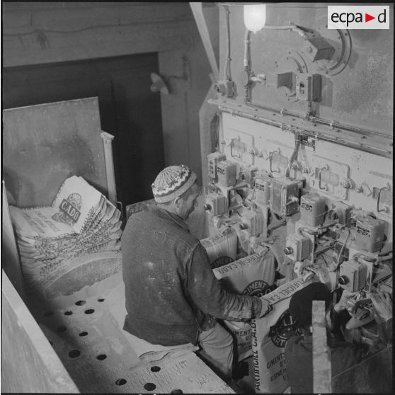 Saint-Lucien. CADO (ciments artificiels d'Oranie). Remplissage automatique des sacs de ciment.