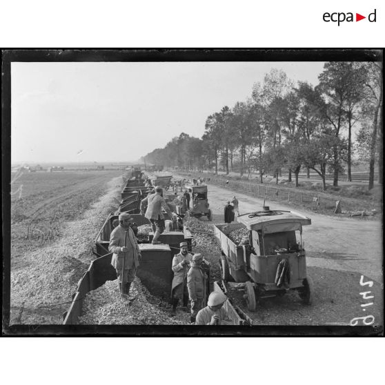 Sur la route d'Amiens à Saint-Quentin, les pierres pour la réfection des routes sont amenées par train et chargées sur auto camion. [légende d'origine]