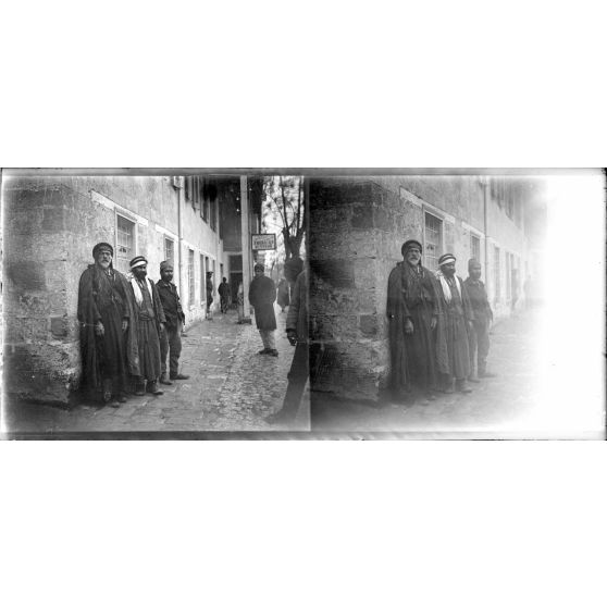 Des portraits d'hommes syriens devant les locaux de la mission américaine. [légende d'origine]