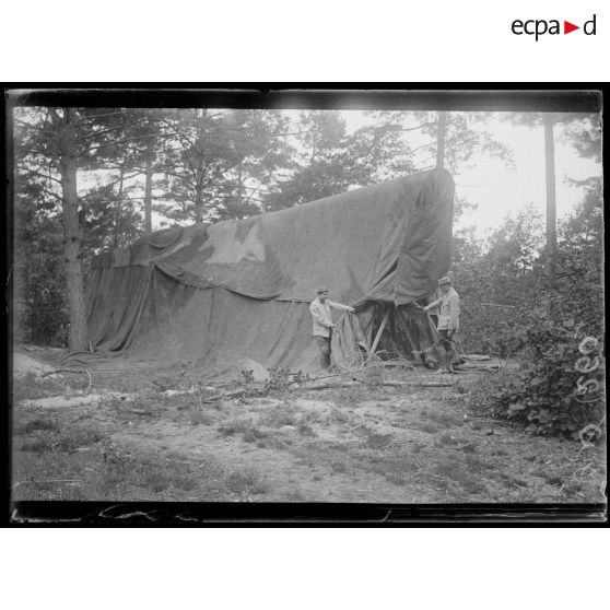[Camouflage d'une pièce d'artillerie sous une bâche.]