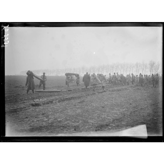 Près de la gare de Muizon, Marne, pose de voie ferrée sur la ligne de Reims. Déchargement  des traverses. [légende d'origine]