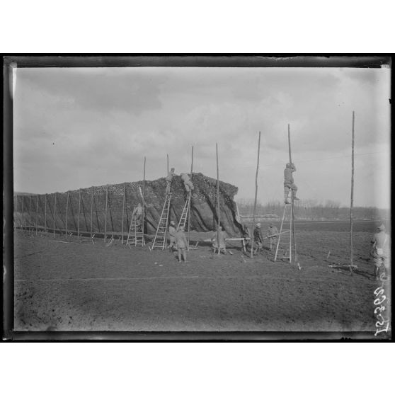 Route de Muizon à Reims, Marne, pose de panneaux pour camoufler la route. [légende d'origine]