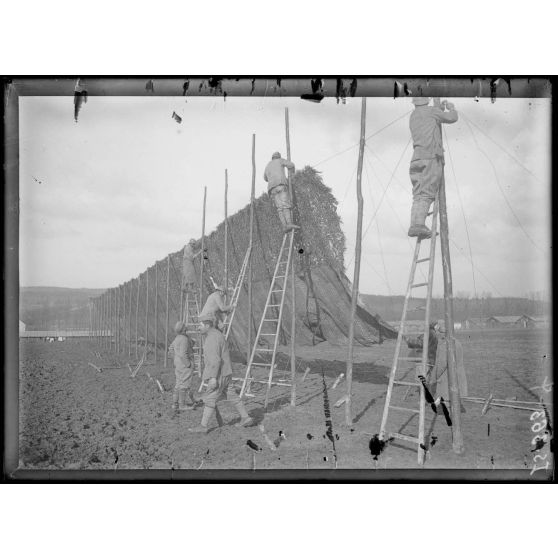 Route de Muizon à Reims, Marne, pose de panneaux pour camoufler la route. [légende d'origine]