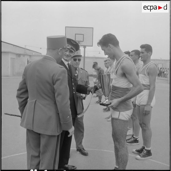 Alger. Stade Marcel Cerdan. Finale d'Afrique du Nord (AFN) de basketball. Le Général Vandeuil remet la coupe à l'équipe gagnante : le 45e régiment du train (RT).