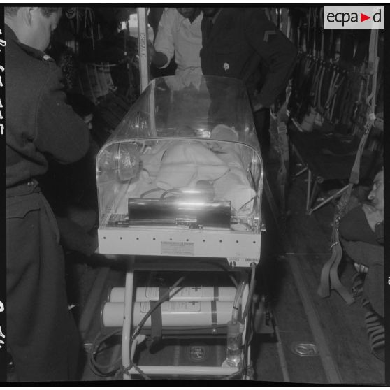 Maison Blanche. Berceau d'incubation avec le bébé à bord de l'avion Nord-2501 Noratlas.