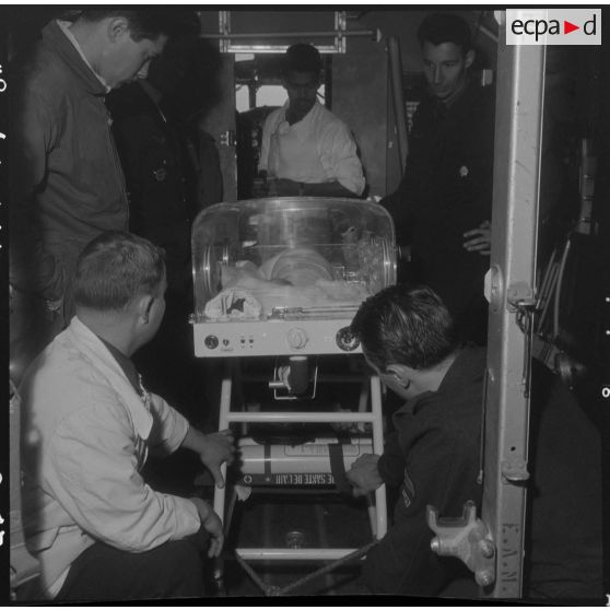 Maison Blanche. Berceau d'incubation avec le bébé à bord de l'avion Nord-2501 Noratlas.