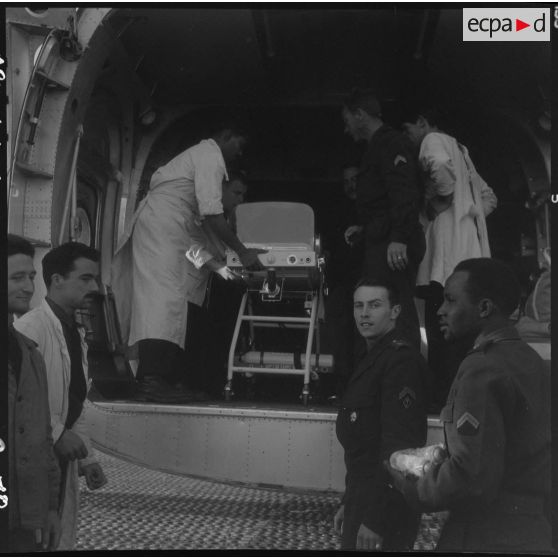 Maison Blanche. Embarquement et installation du berceau d'incubation avec le bébé à bord de l'avion Nord-2501 Noratlas.