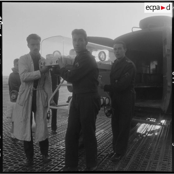 Maison Blanche. Les infirmiers descendant le berceau d'incubation du véhicule sanitaire qui effectuait le transport d'Alger à Maison Blanche.