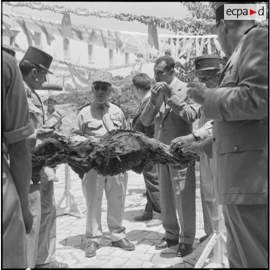 Le général Gambiez et le député d'Alger Kaouah, entourés des officiers dégustent le méchoui.
