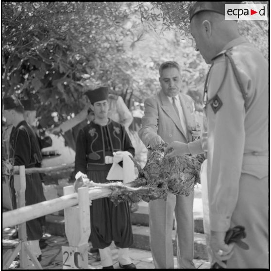 Diverses personnalités, mangeant le méchoui préparé par la 4e compagnie du 9e zouave.