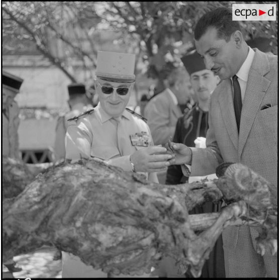 Le général Gambiez et le député Kaouah, mangent le méchoui préparé par la 4e compagnie du 9e zouave.