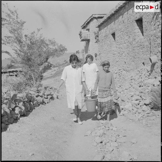 L'équipe médico-sociale itinérante (EMSI), aidant une fille à porter de l'eau à la maison.