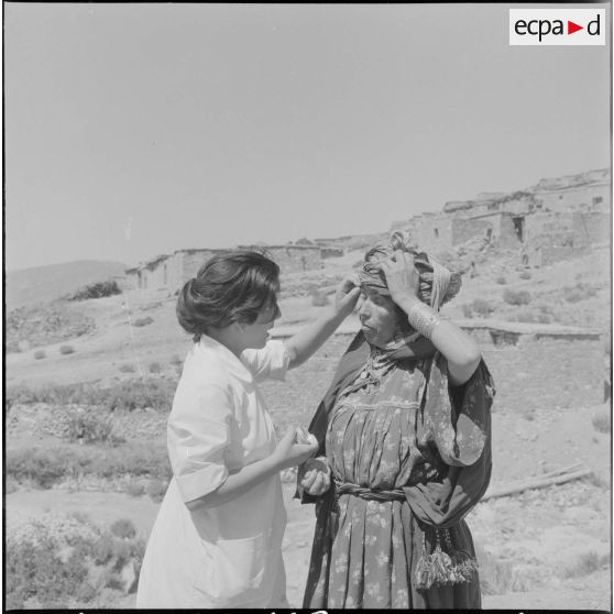 Un membre de l'équipe médico-sociale itinérante (EMSI), soignant une femme.