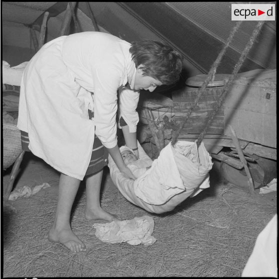 Un membre de l'équipe médico-sociale itinérante (E.M.S.I.), apportant ses soins à un bébé.